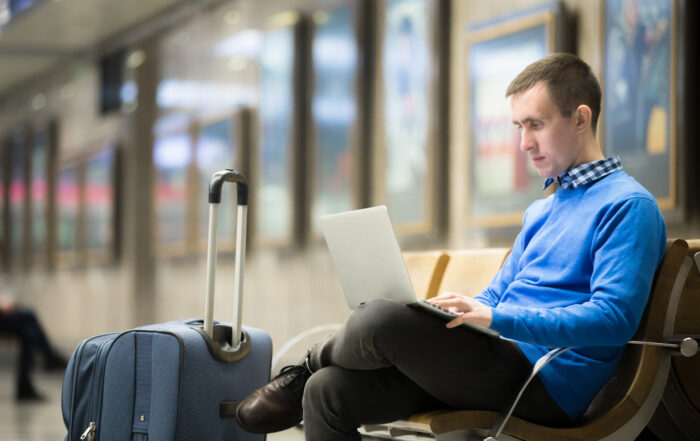Business visitor reviewing documents while waiting at a transport station — representing the process for Canada's Business Visitor Visa.
